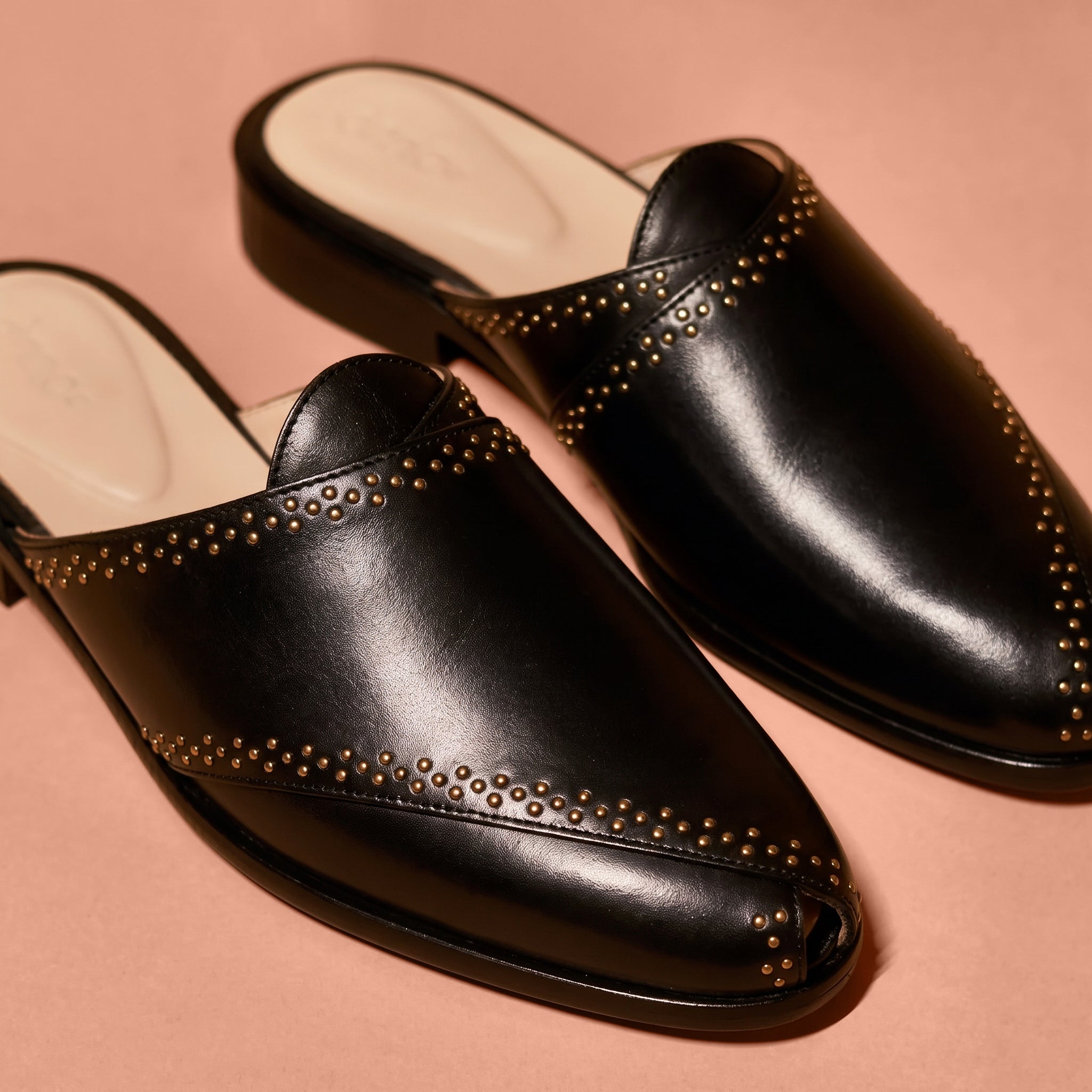 Close-up of golden rivet accents and black leather detailing on Hoffler Pesha Nero