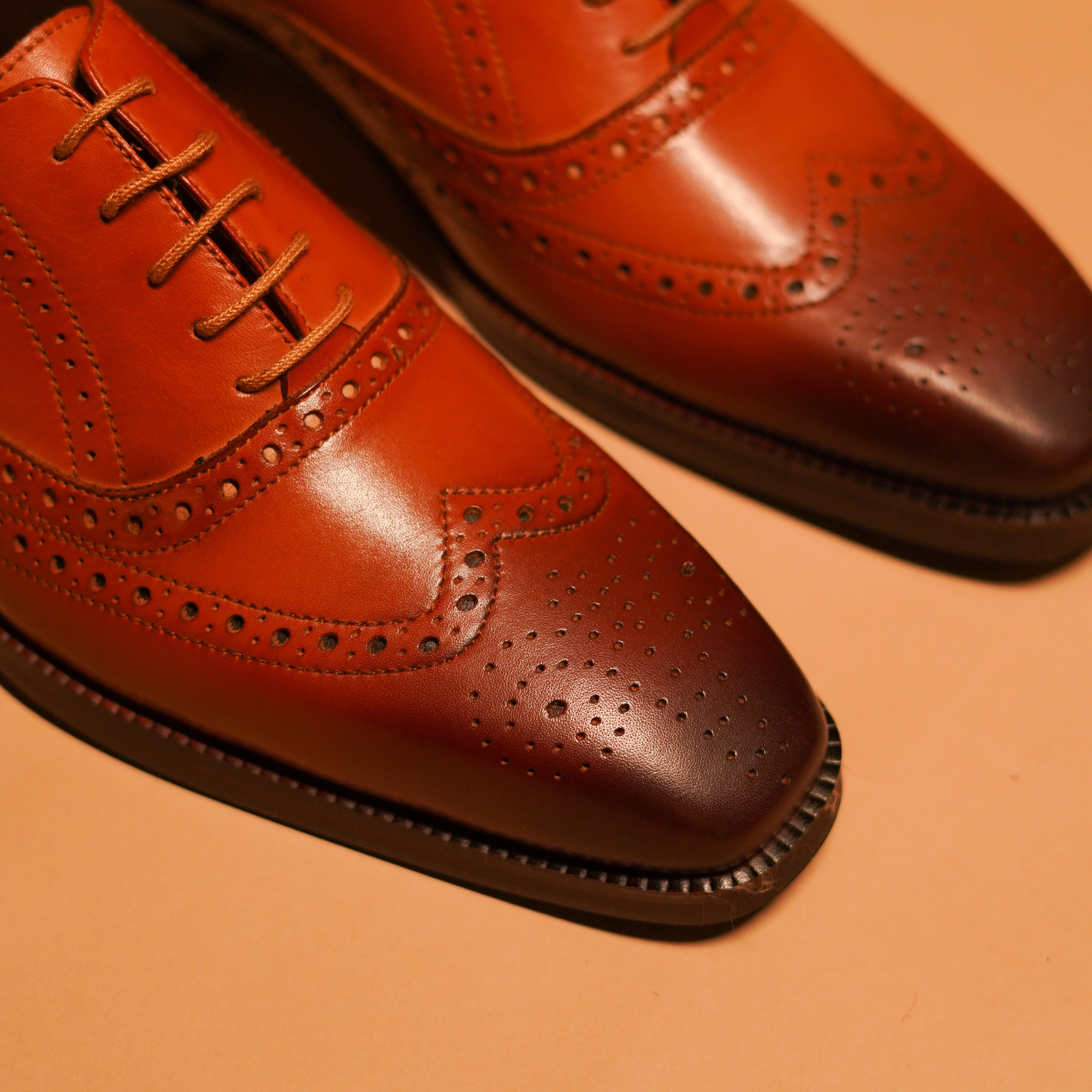 intricate brogue details, Tanino Bronzo craftsmanship, wingtip brogue design, high-quality leather Oxford, elegant men's shoe, dmodot luxury footwear.