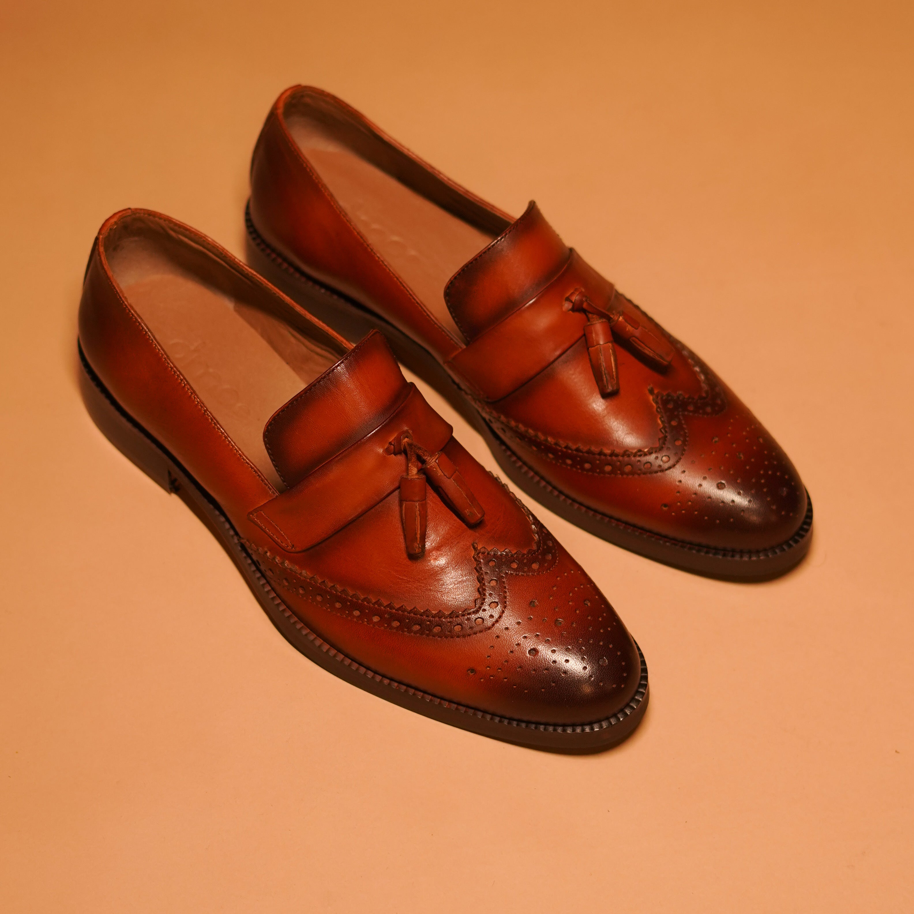 Handcrafted Motivo Broguo loafer in dark tan dual-shade full-grain leather with elegant tassel.