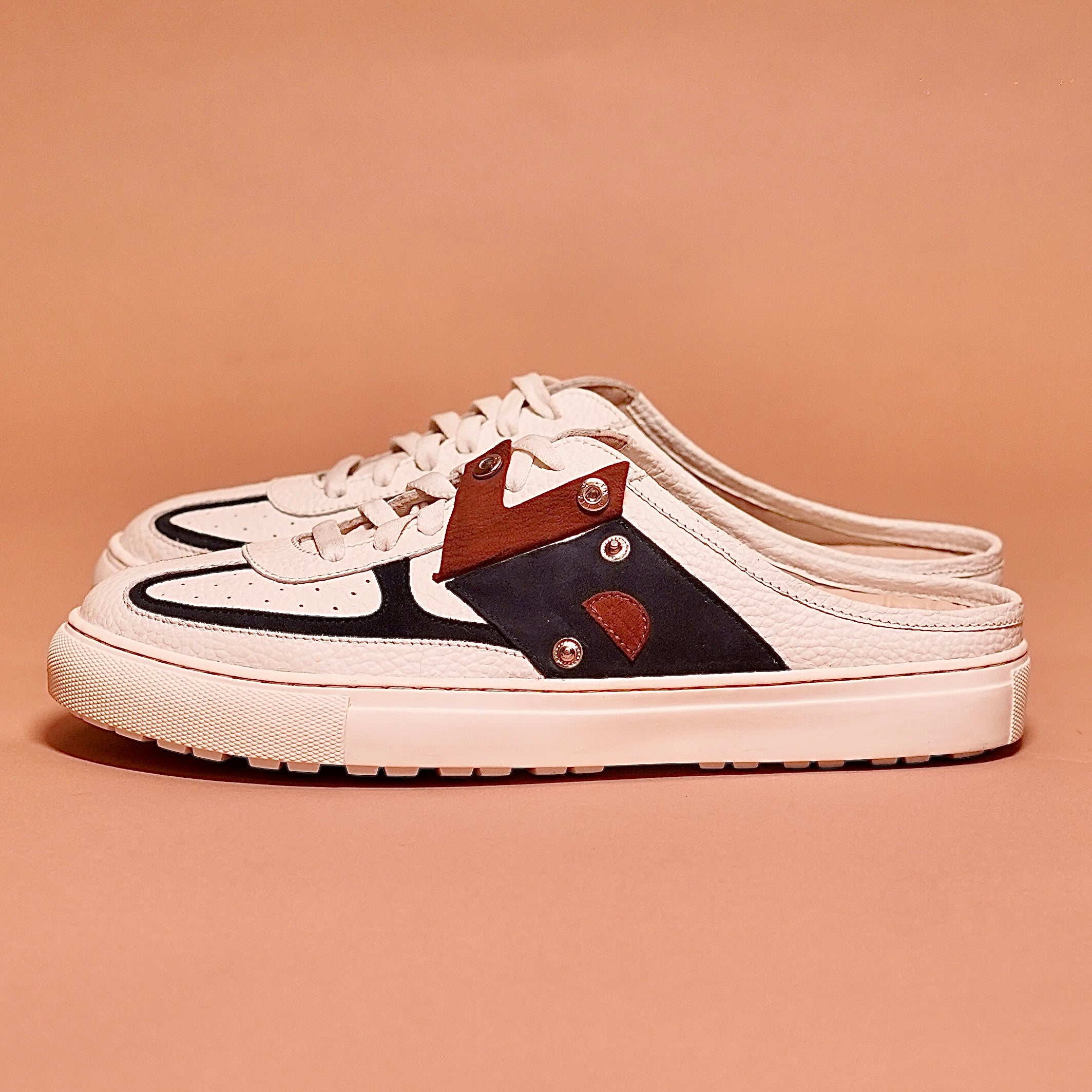 Side view of Freddo Bianco mule sneaker with black and tan accents