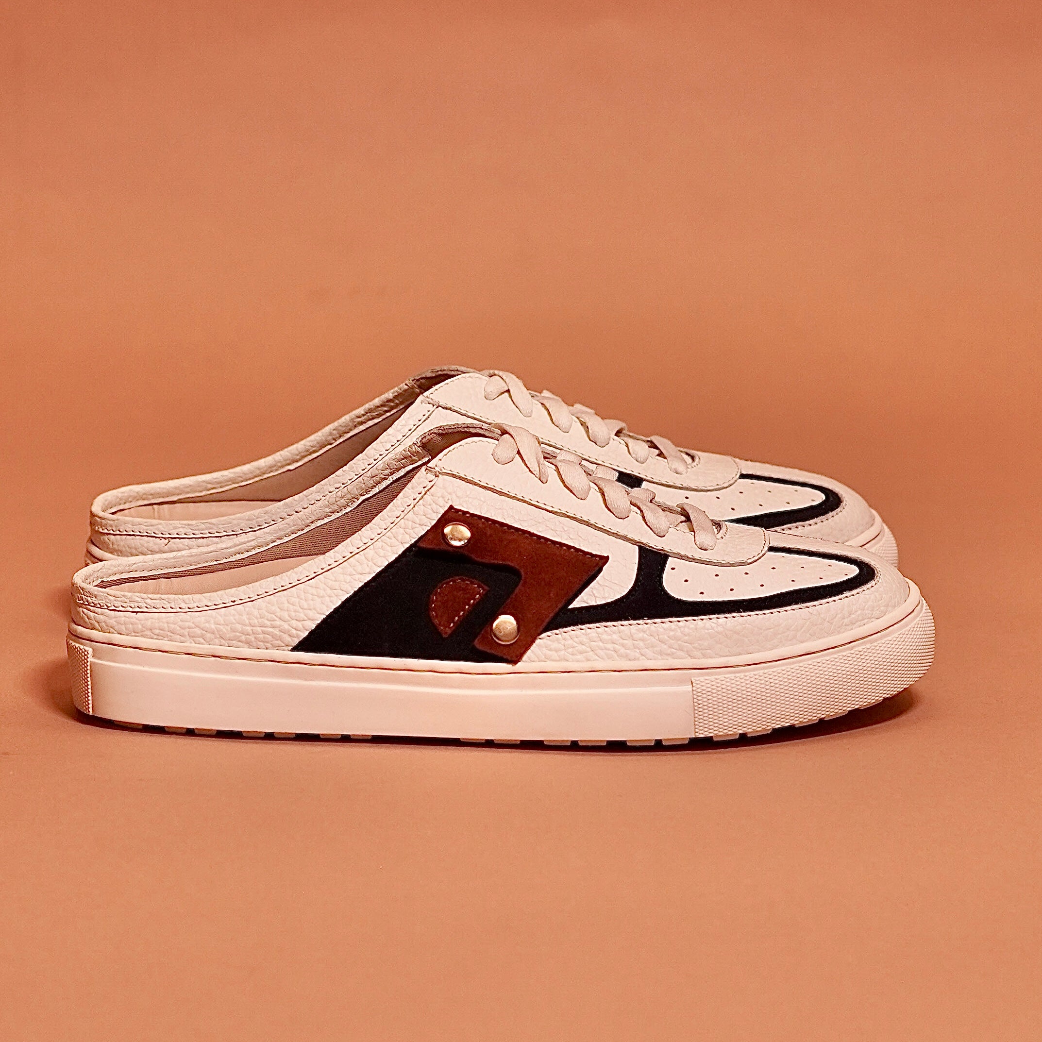 Side view of Freddo Bianco mule sneaker with black and tan accents