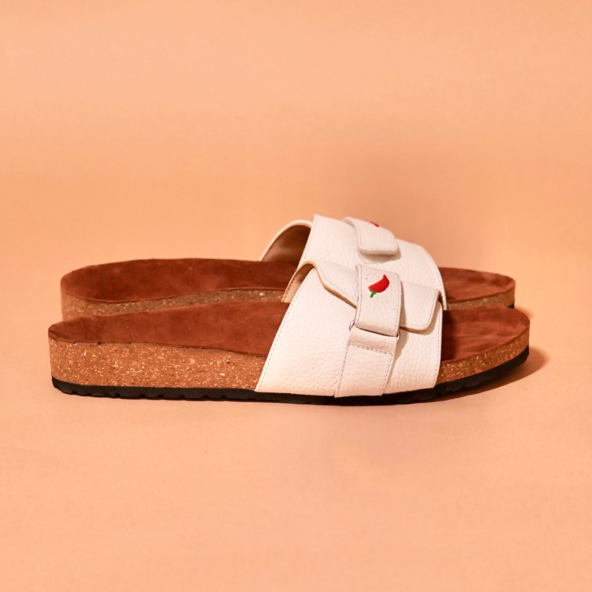 Side view of Salt Slider in white leather with red chilli embroidery
