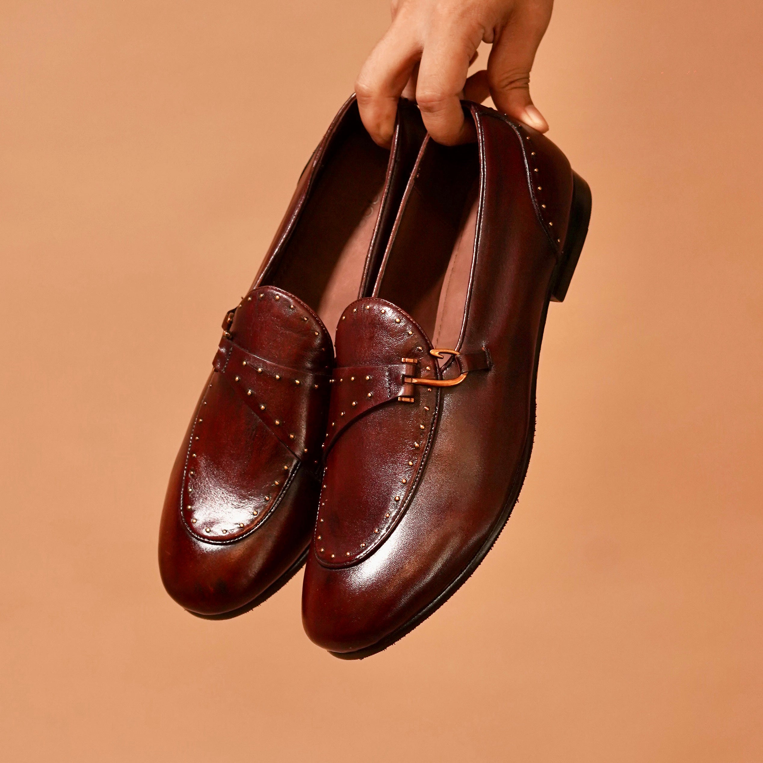 Top view of brown leather loafer with patina finish and metallic accents