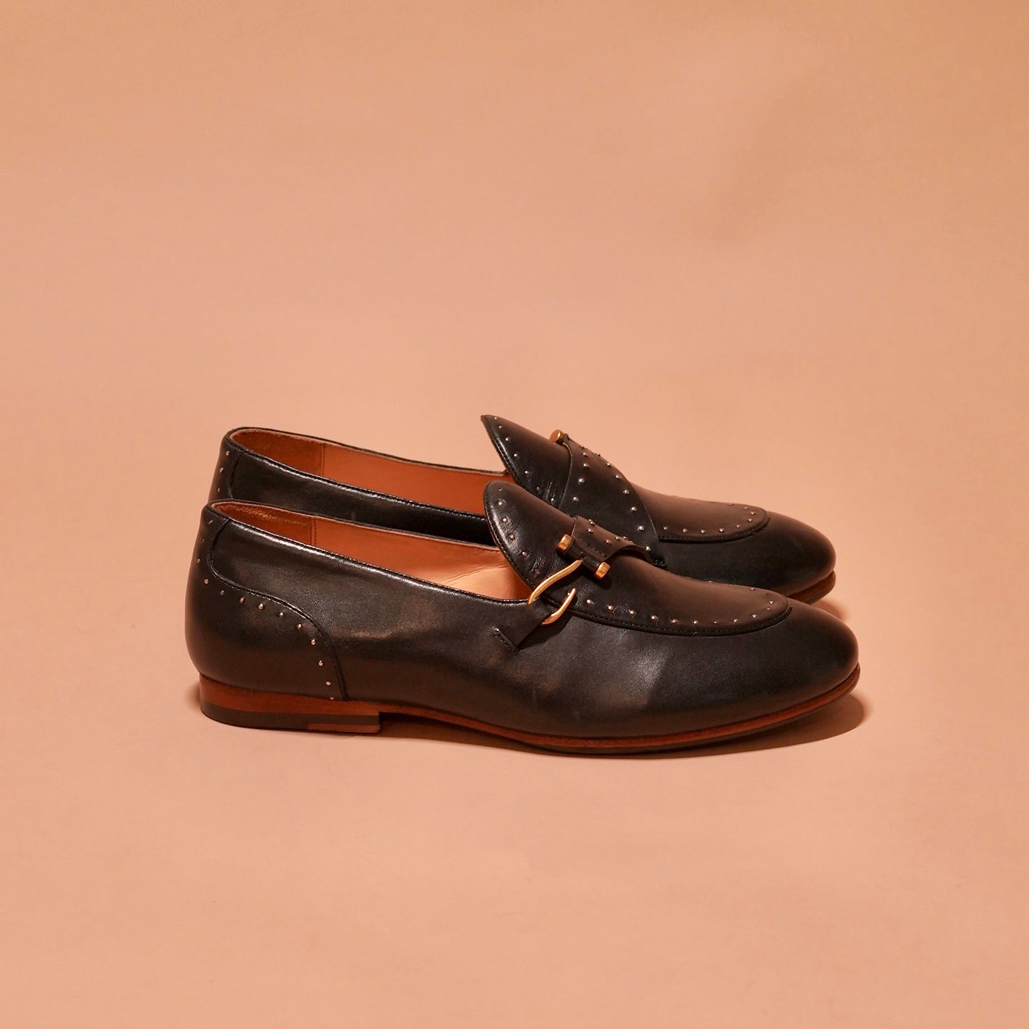 Side view of Motivo Nero Riveto showcasing the Blake-stitched sole and hook accessory.