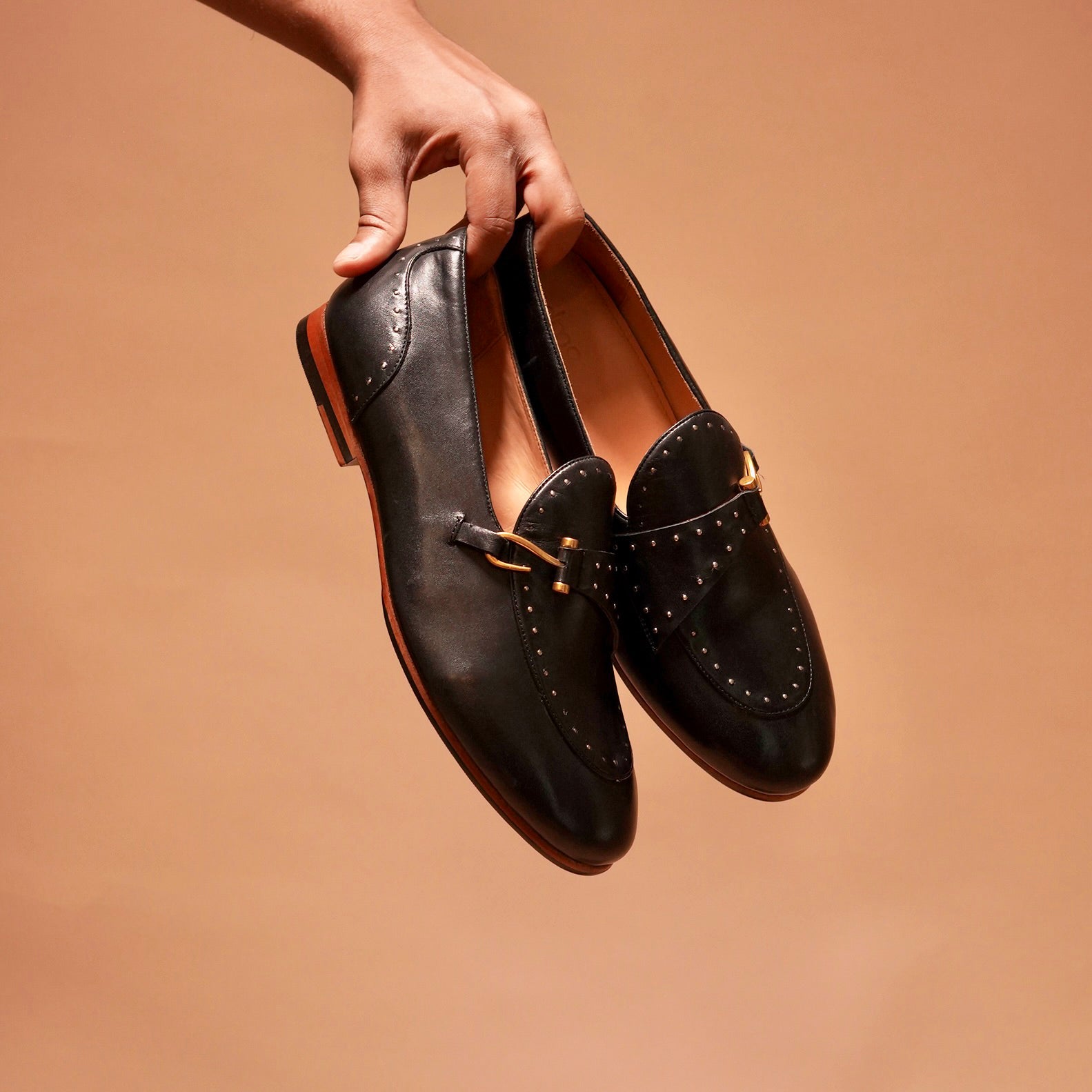 Detailed craftsmanship of Motivo Nero Riveto black leather loafers.