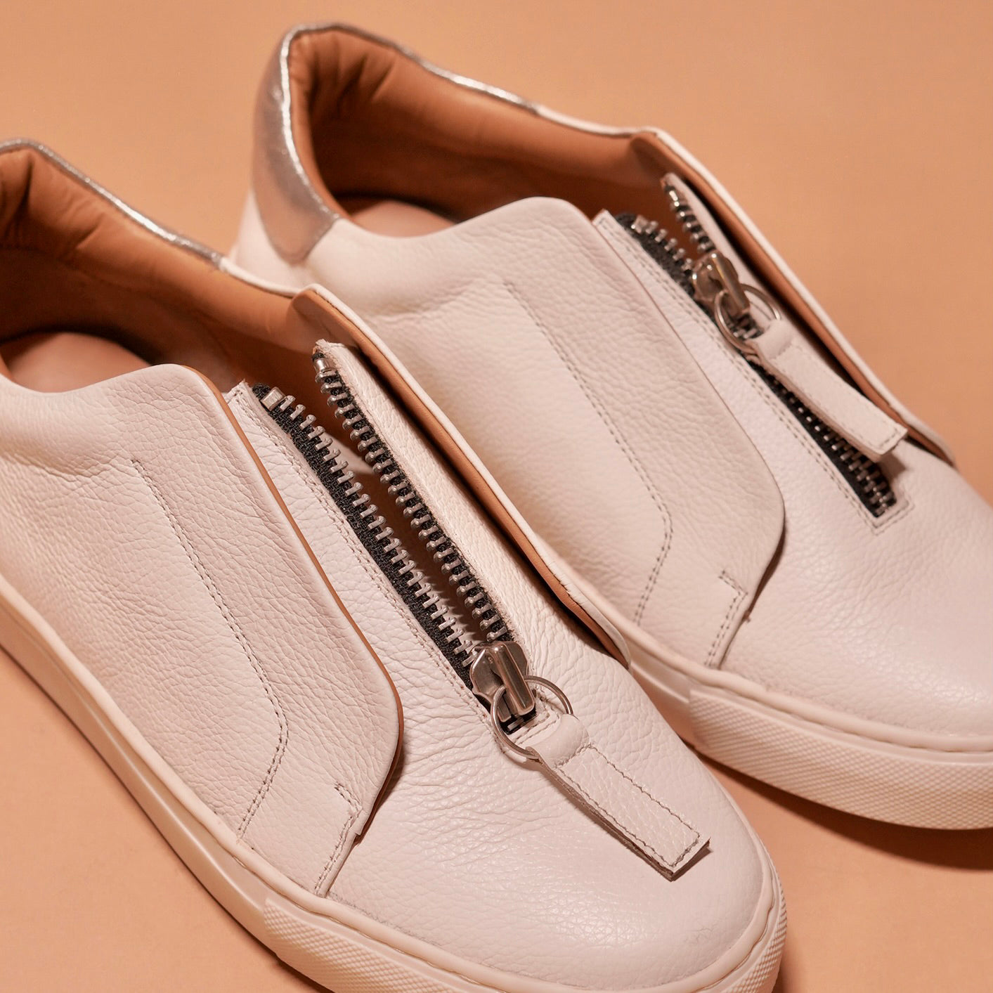 Front view of Pigro Bianco highlighting the sleek design and zip closure.