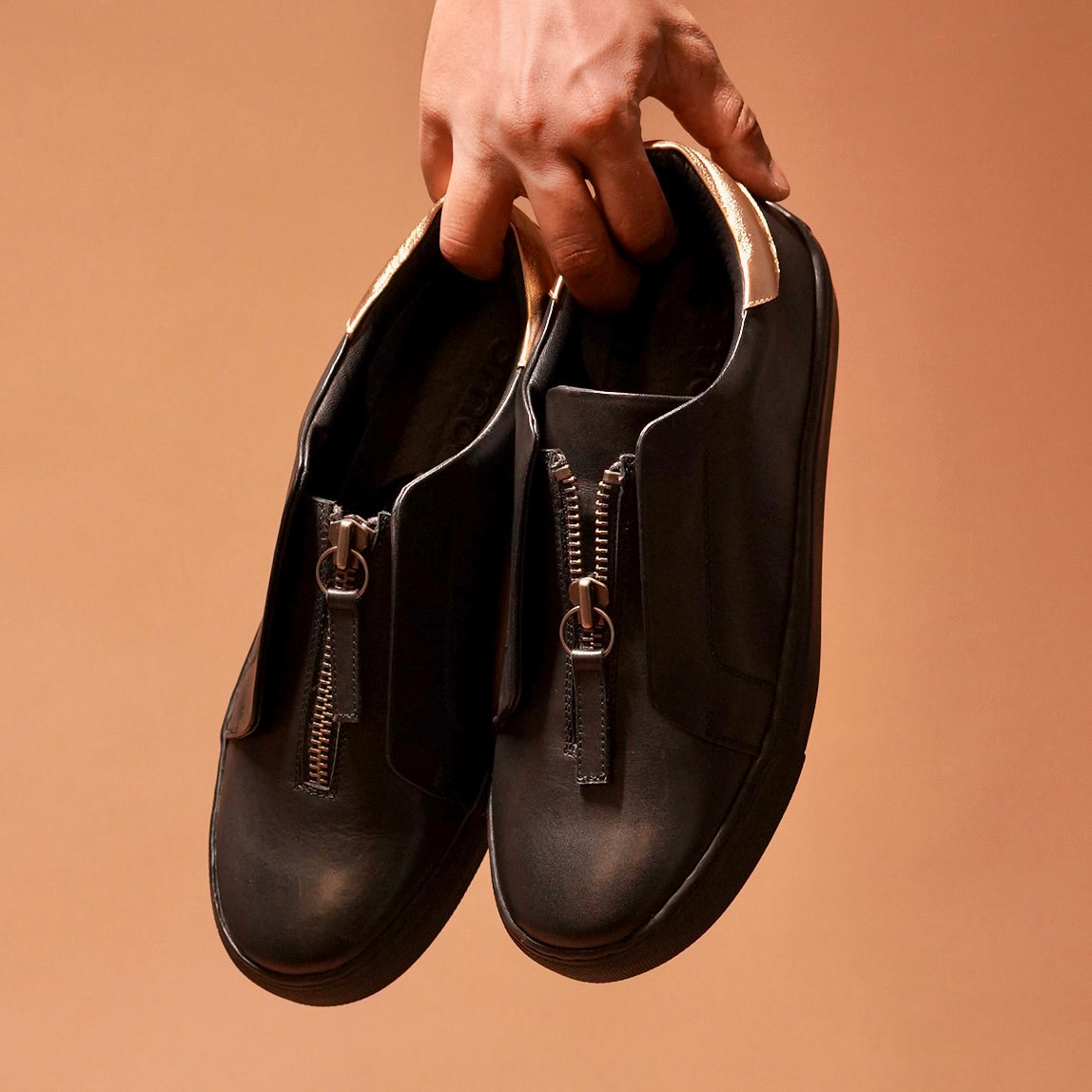 Front view of Pigro Nero highlighting the central zip closure and elegant finish.