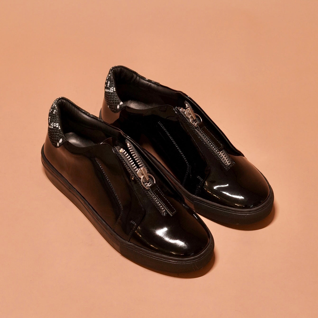 Front view of Pigro Lustro highlighting the central zip closure and elegant finish.