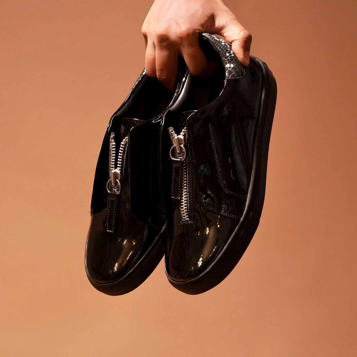 Front view of Pigro Lustro highlighting the central zip closure and elegant finish.