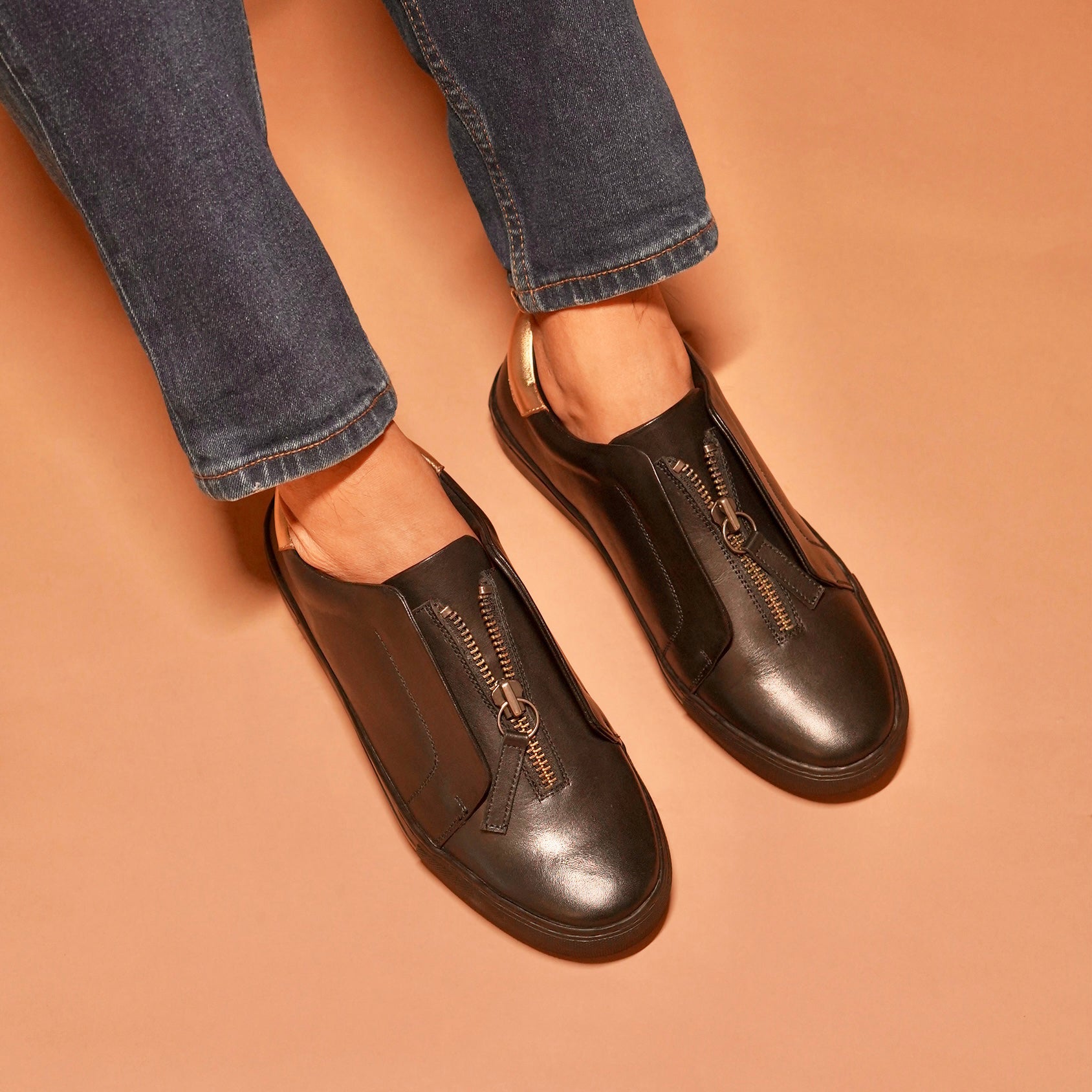 Front view of Pigro Nero highlighting the central zip closure and elegant finish.