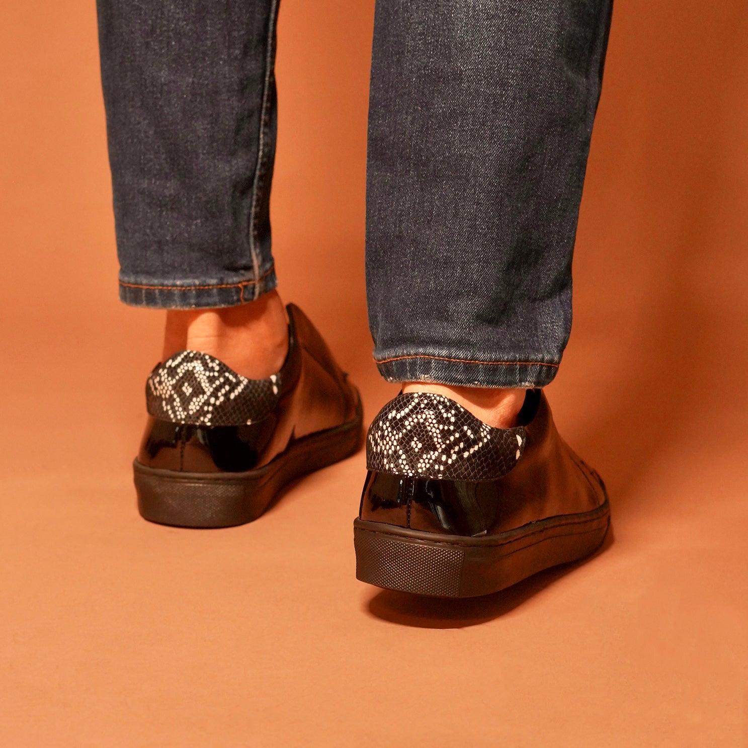 Detailed craftsmanship of Pigro Lustro black patent leather lazy sneakers.