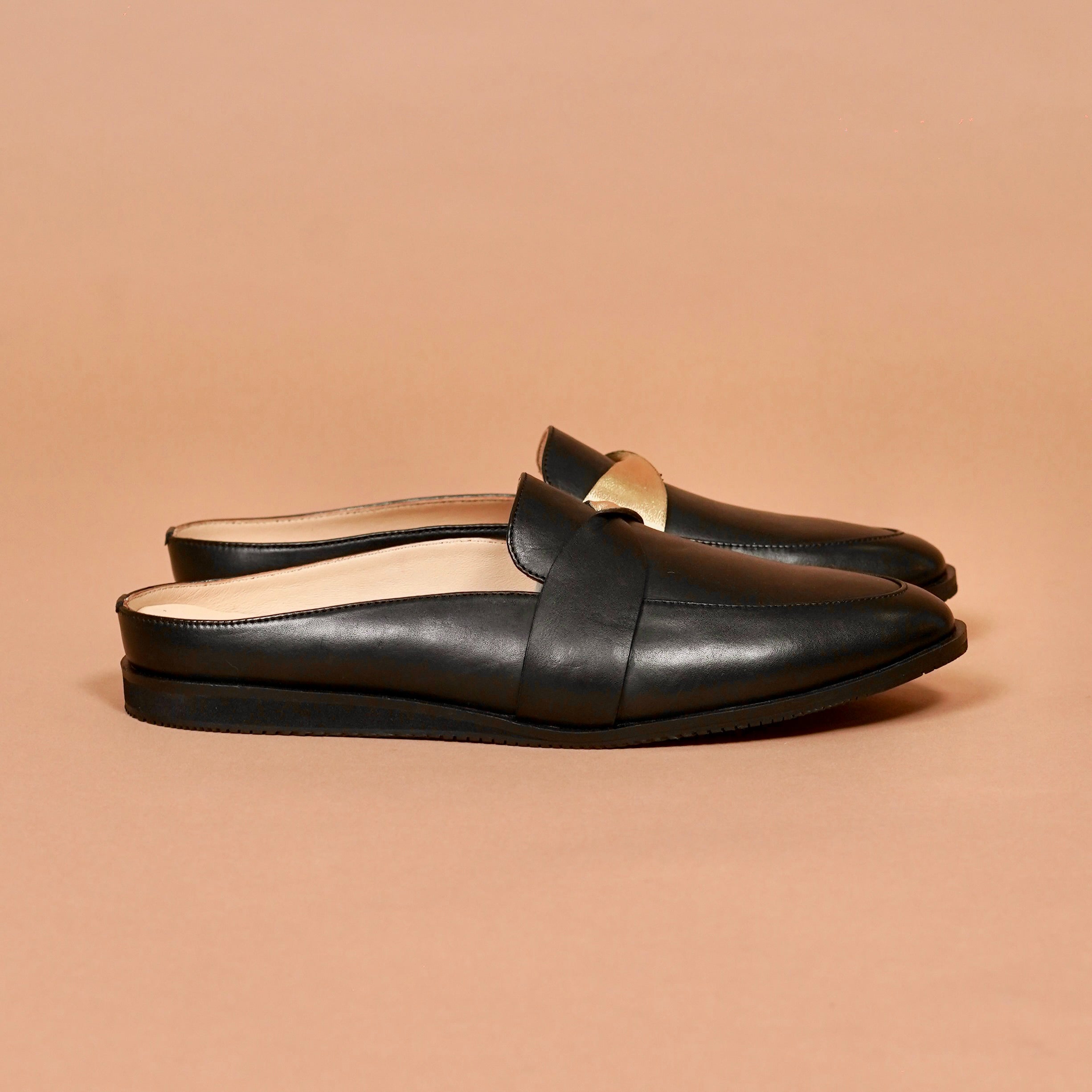 Side view of Hoffler Nero Doro black leather mule with gold accent