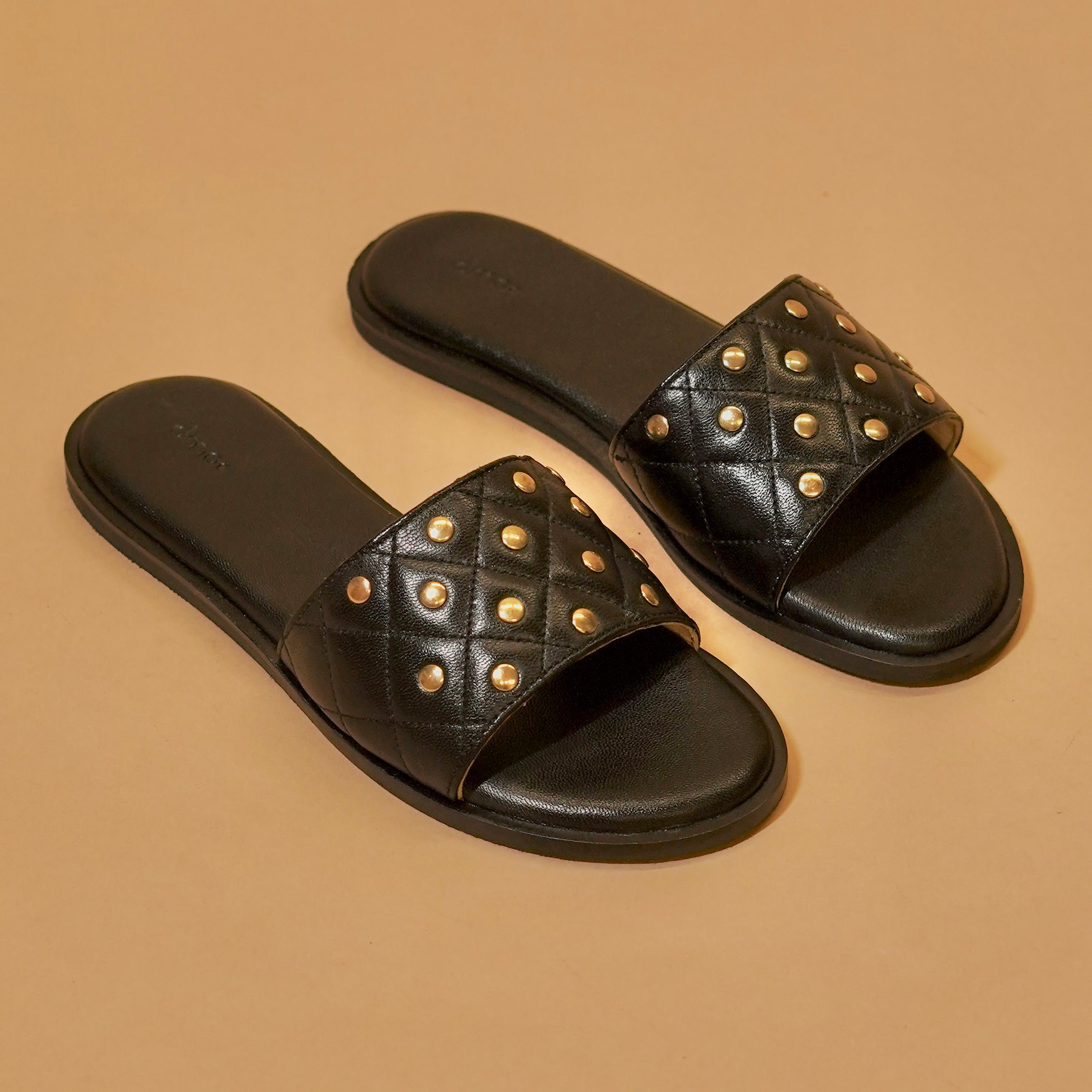 Quilted black leather slider with brass rivets